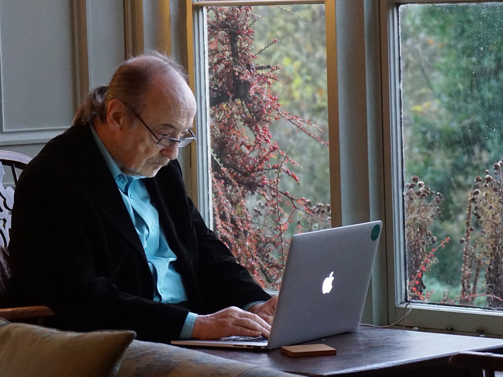An older person and a carer looking at a care plan together on a laptop
