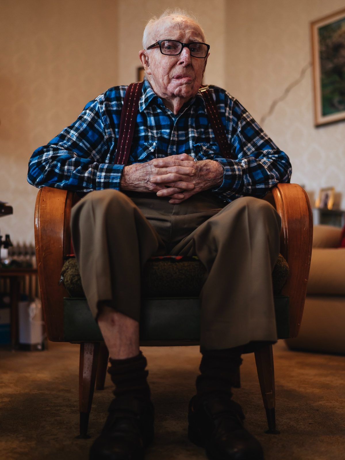 An older man sitting comfortably in his own armchair at home